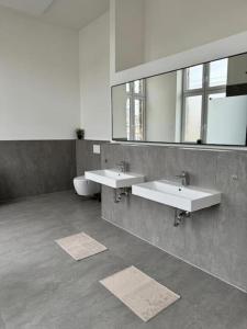 a bathroom with two sinks and a mirror at Heaven Homes - 15 Gehmin bis zur Innenstadt in Düsseldorf