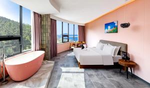 a bedroom with a bathtub and a bed and a tub and a sink at Weihai Kiki Secret Garden Hotel in Sunjiatuan