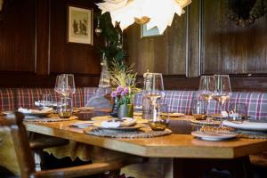 a wooden table with wine glasses and plates on it at Arlberg Stuben - das kleine, feine Hotel in Stuben am Arlberg +50 photos
