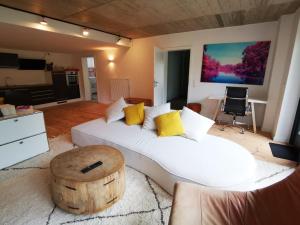 a living room with a white bed and a wooden floor at Wohlfühloase in Windeby