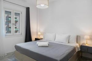 a bedroom with a bed with a towel on it at Sunset Realty Apartment in Ano Syros