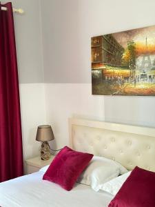 a bedroom with a bed and a painting on the wall at Rose Apartament Sarande in Çukë