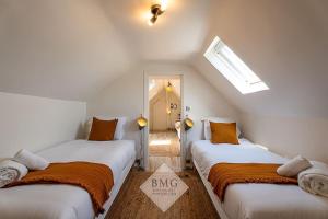 a room with two beds with orange and white sheets at Villa Solaris Disneyland in Chalifert +44 photos