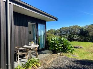 a small patio with a table and chairs on a house at Raglan Studio at The Coastal Retreat in Raglan