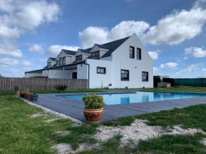 a house with a swimming pool in front of it at Fynbos Guest Houses in Hopefield