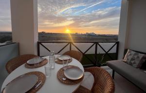 a white table with chairs and a view of the sunset at Casa Fin del Mundo El Cotillo in Cotillo