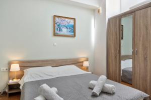 a bedroom with a bed with two towels on it at Voula Apartment in Ermoupoli
