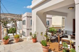 a balcony of a house with potted plants at Voula Apartment in Ermoupoli