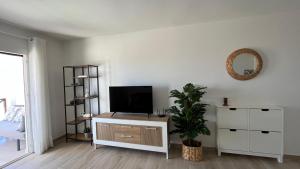 a living room with a flat screen tv on a cabinet at Casa Fin del Mundo El Cotillo in Cotillo