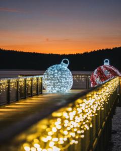 drie verlichte sneeuwbollen op een pier met verlichting bij MOLO LIPNO RESIDENCE in Lipno nad Vltavou