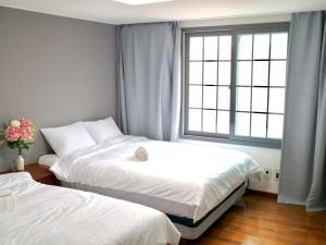 two beds in a room with a window at Family Pent House in Seoul