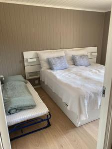 a bedroom with a white bed with blue pillows at Oppgradert leilighet i Tråstølen in Skulestadmo