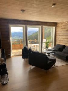 a living room with couches and a view of a mountain at Oppgradert leilighet i Tråstølen in Skulestadmo