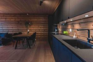 a kitchen with a sink and a table with chairs at Oppgradert leilighet i Tråstølen in Skulestadmo +23 photos