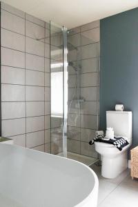 a bathroom with a bath tub and a toilet at The Parade -Corner Plot Getaways in Redcar +45 photos