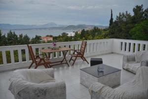 a patio with chairs and a table on a balcony at Caecilia & Lawrence Villa in Chalkida