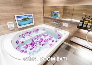 a bathroom with a tub with purple flowers in it at Hotel Pasela Living Shinjuku in Tokyo