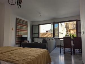 una camera da letto con un letto e un soggiorno di Apartamentos Plaza a Cordoba