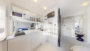 a white kitchen with a sink and a microwave at Sloane Cloisters 767 in London