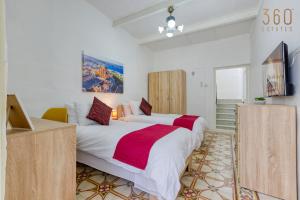 a bedroom with a large bed and a television at Authentic Townhouse with backyard in Sliema by 360 Estates in Sliema