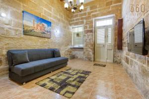 a living room with a couch in a stone wall at Authentic Townhouse with backyard in Sliema by 360 Estates in Sliema +45 photos