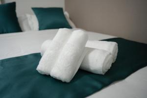 due rotoli di asciugamani bianchi seduti su un letto di L house 101 ad Osaka