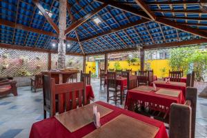 a restaurant with red tables and chairs and a roof at Pousada Telhado Azul in Abraão