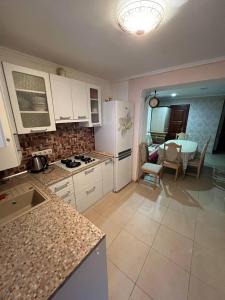 a kitchen with white cabinets and a table and a dining room at Комфорт in Polyana +10 photos