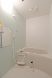 un bagno bianco con lavandino e specchio di L house 101 ad Osaka Altre 22 foto