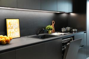 a kitchen with a sink and a counter top at Luca - Luxury Park-View Apt with Balcony & Parking in Bucharest