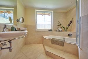 a bathroom with a sink and a bath tub and a sink at Arlberg Stuben - das kleine, feine Hotel in Stuben am Arlberg
