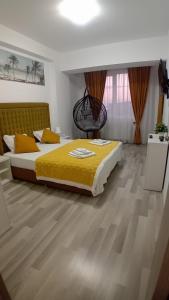 a bedroom with a bed with a yellow comforter at Apartament COSTA in Mamaia