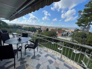a balcony with a table and chairs and a view at Apartment Olive Malinska - Panoramic Sea View in Malinska
