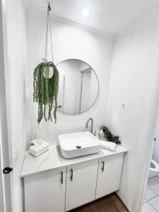 a white bathroom with a sink and a mirror at SERENITY STAYS Mount Martha Mornington Peninsula in Mount Martha