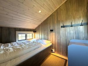 a bedroom with a bed in a wooden wall at Large cabin with spectacular views in Geilo in Geilo