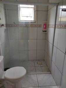 a white bathroom with a toilet and a window at Casa mobiliada privativa in Caiçara +18 photos