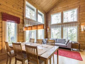 a dining room with a table and a couch at Holiday Home Uuvana by Interhome in Äkäslompolo