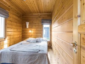 a bedroom with a bed in a wooden cabin at Holiday Home Uuvana by Interhome in Äkäslompolo
