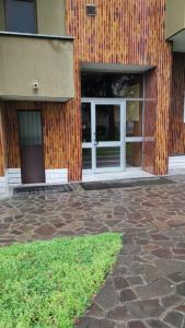 ein Gebäude mit zwei Türen und einer Ziegelwand in der Unterkunft Bnbook Monolocale Beatrice Rho Fiera in Rho