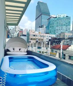 a hot tub on a balcony with a view of a city at Family Pent House in Seoul +5 photos