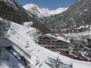 a ski resort with a ski lift in the snow at Ushuaia, The Mountain Hotel in Arinsal
