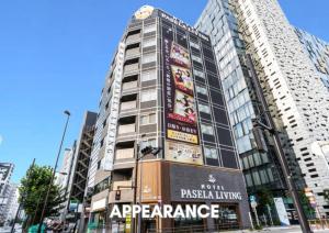a tall building with a sign in front of it at Hotel Pasela Living Shinjuku in Tokyo