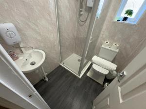 a bathroom with a shower and a toilet and a sink at North Coast Hotel in Blackpool +8 photos