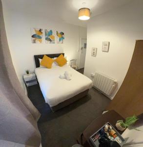 a bedroom with a white bed with yellow pillows at North Coast Hotel in Blackpool
