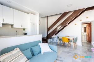 a living room with a blue couch and a table at Torre Argantonio by LiveWork in Cádiz