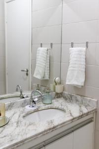 a bathroom counter with a sink and a mirror at Apartamento vista mar Atalaia todos quartos climatizados in Aracaju