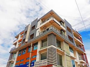达文盖雷Savanur Deluxe Lodge的一座高大的建筑,旁边设有阳台