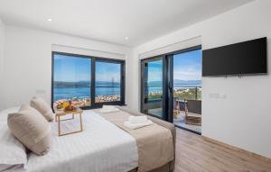 a white bedroom with a large bed and a television at Awesome Home In Crikvenica With Sauna in Crikvenica +36 photos