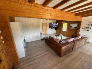 a large living room with a couch and a tv at Le Chalet aux Trésors ! in Notre-Dame-dʼAllençon
