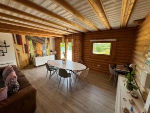 a living room with a couch and a table at Le Chalet aux Trésors ! in Notre-Dame-dʼAllençon